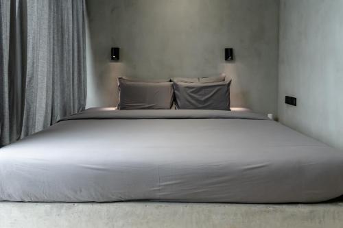 a large white bed in a room with a window at Predmet Babakan Canggu Bali in Dalung