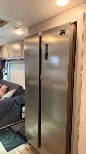 a stainless steel refrigerator in a room with a bed at Private Cozy R/V , for your enjoyment in Tamiami