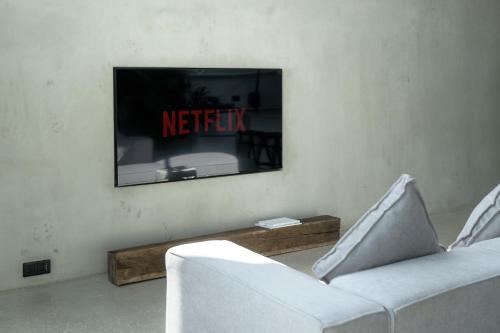 a living room with two white chairs and a television at Predmet Babakan Canggu Bali in Dalung