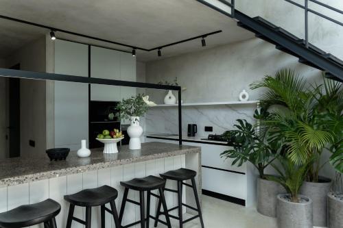a kitchen with black stools at a counter at Predmet Babakan Canggu Bali in Dalung