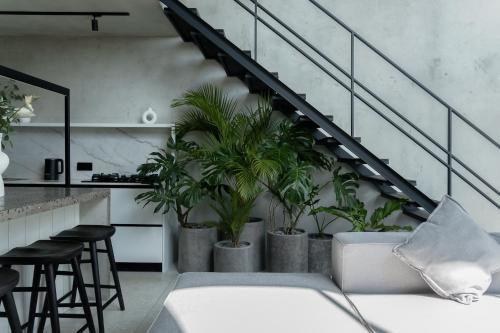 a living room with a staircase with potted plants at Predmet Babakan Canggu Bali in Dalung