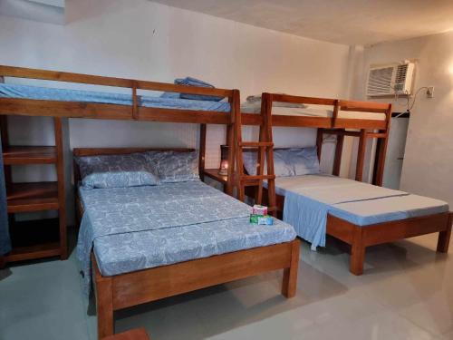 Habitación con 2 literas, 1 cama y 1 mesa. en Sea Breeze Beach Resort, en Mabubua