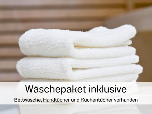 a stack of white towels on a table at Casa-MiU am Wasser - Olburgen - perfekt für Familien - mit Freibad, Sauna, Restaurant und Spielplatz in Olburgen