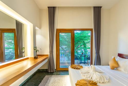 a bedroom with a bed and a large window at Family Style 3-Bedroom Suite by Baahu Villa in Siem Reap