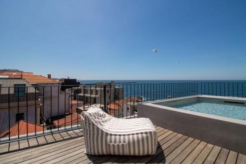 a chair sitting on a deck next to a swimming pool at EDiTiON 309 - Luxury Seafront 2BR Apartments in Porto