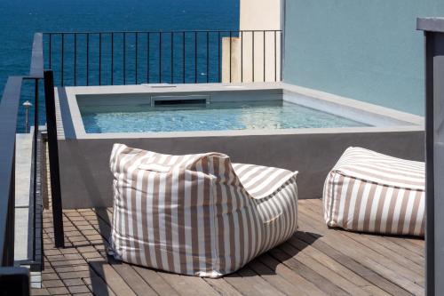 two pillows sitting on a deck next to a swimming pool at EDiTiON 309 - Luxury Seafront 2BR Apartments in Porto