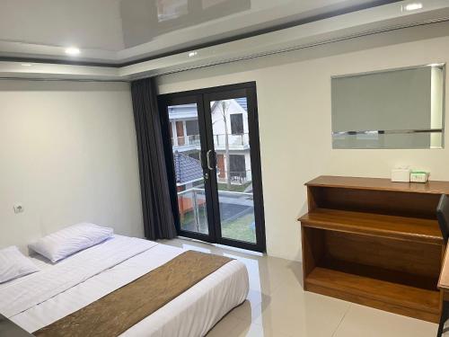 a bedroom with a bed and a dresser and a window at Grand Wijaya Hotel dan Villa Sarangan in Sarangan