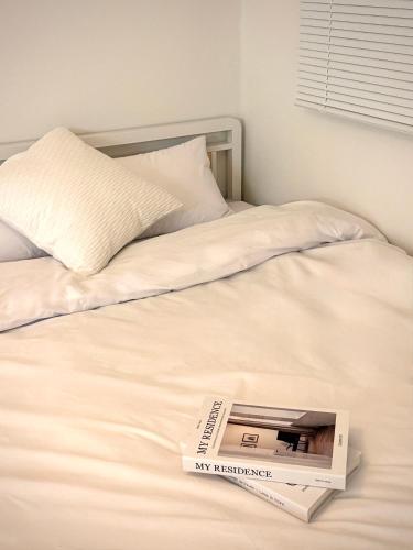 a book sitting on top of a bed at HausKomma 서울 홍대,이태원,명동 짐보관 무료 주차 엘레베이터 새아파트 in Seoul