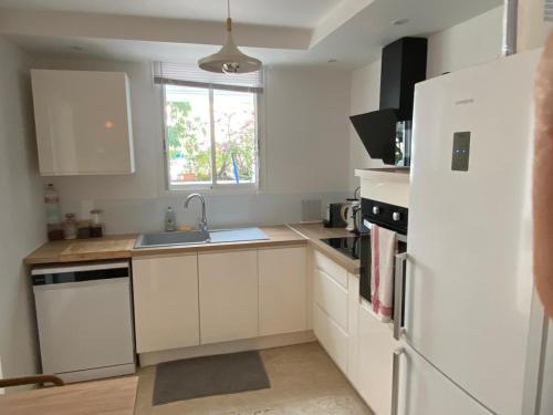 a kitchen with white cabinets and a sink and a refrigerator at YATCH view II in Pointe-à-Pitre
