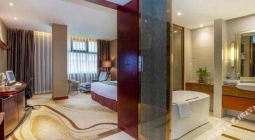 a hotel room with a bed and a bathroom at Quanzhou Jinjiang Hollyston Hotel in Quanzhou