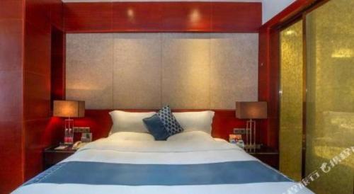 a bedroom with a large bed with two lamps at Quanzhou Jinjiang Hollyston Hotel in Quanzhou