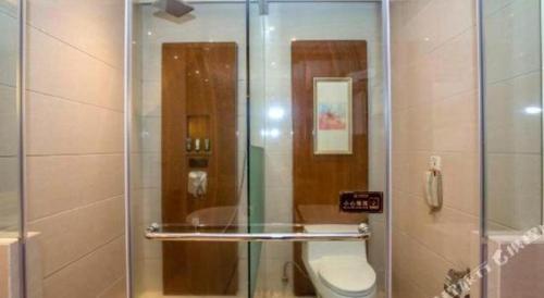 a glass shower with a toilet in a bathroom at Quanzhou Jinjiang Hollyston Hotel in Quanzhou