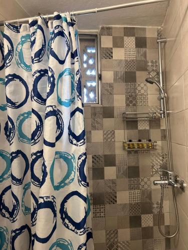 a bathroom with a shower with a blue and white shower curtain at ΗΒΗ in Athens