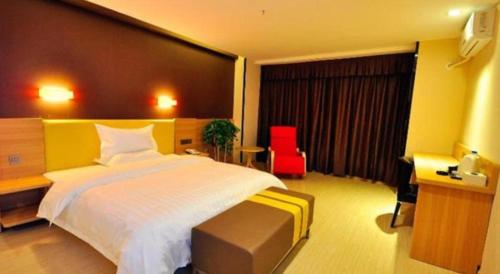 a bedroom with a large bed and a red chair at 7 Days Premium Dezhou Qingyun Nanhuan Building Materials Market in Dezhou