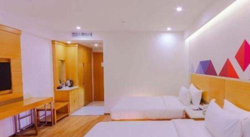 a bedroom with a bed and a desk and a television at Borrman Hotel Zhanjiang Shimao Building High-speed Railway Station in Zhanjiang