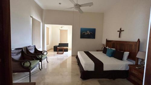 a bedroom with a large bed and a chair at Hermoso departamento listo para tu descanso in Santa Cruz Huatulco