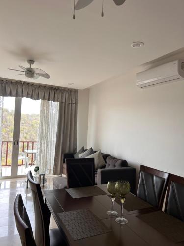 a dining room with a table and a couch at Hermoso departamento listo para tu descanso in Santa Cruz Huatulco