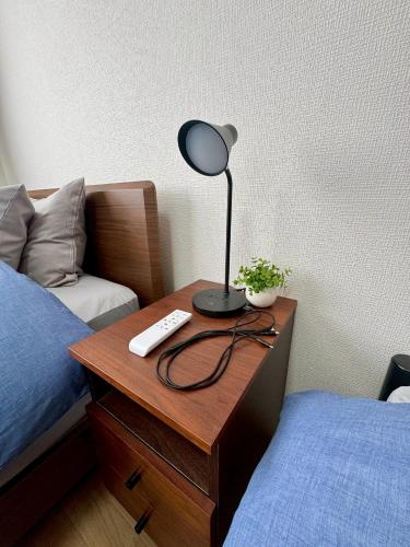 a lamp on a table next to a bed at オホーツク海を一望できる宿 Stay ABASHIRI BAY in Abashiri