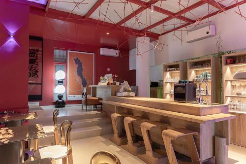 a restaurant with a bar with wooden tables and chairs at Dali Upland International Youth Hostel, near the south gate of the ancient city ,5 mins walk to the old town, Close to Er Hai Lake, convenient payment and visa cards are accepted in Dali