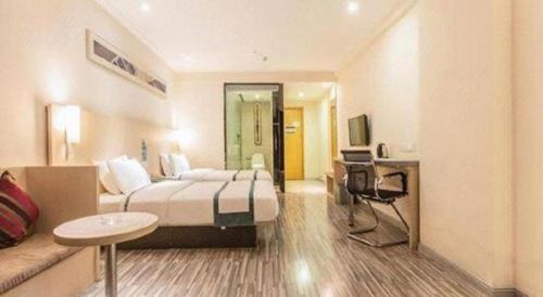 a large hotel room with a bed and a desk at City Comfort Inn Qingyuan Longtang Light Rail Changlong in Qingyuan