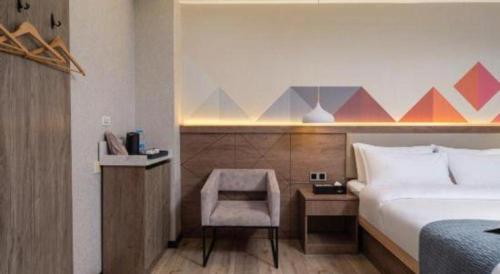 a hotel room with a bed and a chair at Borrman Hotel Yuxi Yuxing Road in Yuxi