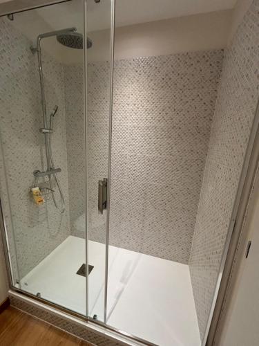 une douche avec une porte vitrée dans une salle de bain dans l'établissement Studio lumineux à Portel des corbières, à Portel-des-Corbières