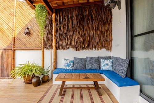 a patio with a blue couch and a table at SeaSalt BeachFront Holiday Home, Private pool, 2 Bedroom house in Chaloklum
