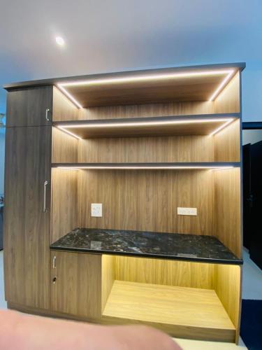 a wooden cabinet with a shelf in a room at The SUNset, Zirakpur 3bhk flat for families only in Zirakpur