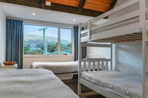 une chambre avec deux lits superposés et une fenêtre dans l'établissement Mid-Century by the Beach, à Christchurch