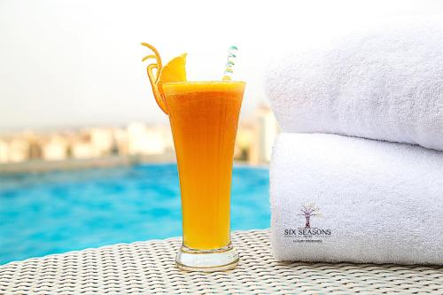 a glass of orange juice sitting on a table next to towels at Six Seasons Hotel in Dhaka