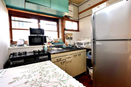 a kitchen with a stainless steel refrigerator and a stove at まんのう清流庵 in Manno