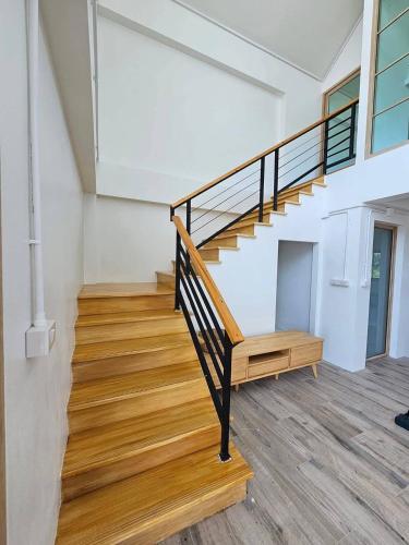 a staircase in a house with wooden flooring at Tara Vela in Chumphon