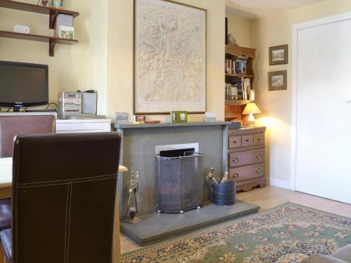 een woonkamer met open haard en tv bij Causey View in Keswick