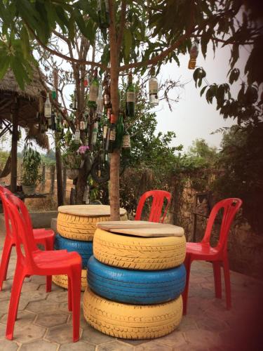 two red chairs and a table with a tree at Bunyong Homestay in Siem Reap