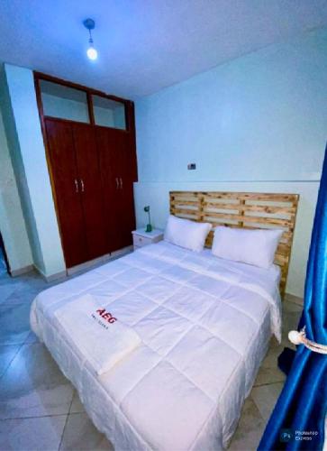 a bedroom with a large white bed with a red door at Stress free massage house in Nalakonge