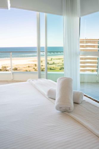 a bedroom with a bed with a view of the ocean at Coastal Penthouse 3BR Luxe Living Over Kirra Beach in Gold Coast
