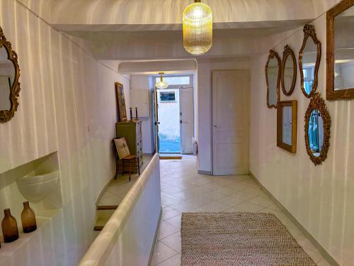 a hallway of a home with a staircase and a mirror at Maison de village avec vue panoramique proche Gordes in Joucas