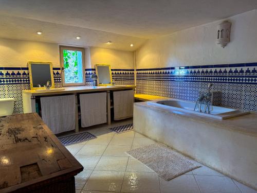 a large bathroom with a tub and a sink at Maison de village avec vue panoramique proche Gordes in Joucas