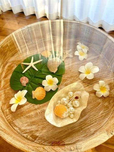 a glass plate with shells and flowers on a table at Kukuna外房 in Mobara