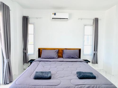a bedroom with a large bed with two pillows at House Saeki in Wok Tum