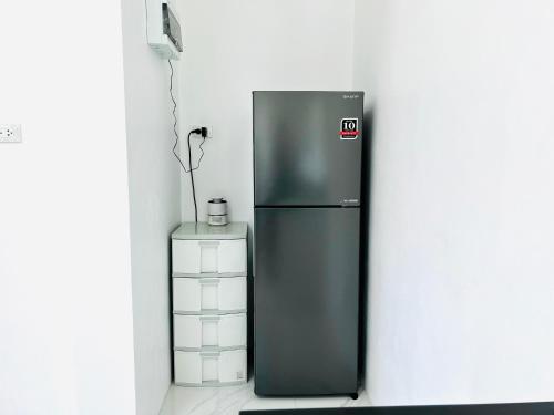 a black refrigerator next to a wall at House Saeki in Wok Tum