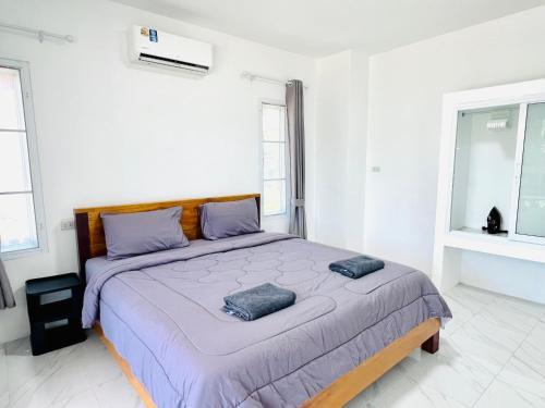 a bedroom with a large bed with two pillows on it at House Saeki in Wok Tum