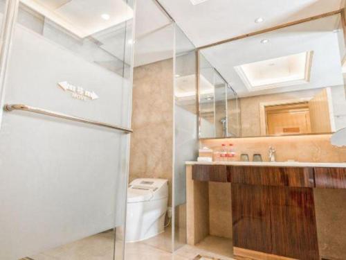 a bathroom with a toilet and a sink and a mirror at Shanghai Fuyue Hotel in Shanghai