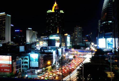 a busy city street at night with many cars at Hotel Clover Asoke - SHA Extra Plus in Bangkok