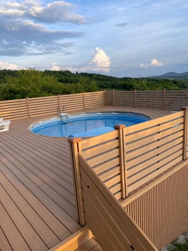 a hot tub on a deck with a wooden fence at Panorama Kosmaj in Drumine
