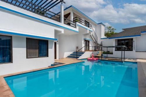 a swimming pool in front of a house at CASA DIOS Luxury Villas in Khandala