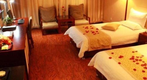 a hotel room with two beds and a desk at GreenTree Inn Taiyuan PinGYAng Road Business Hotel in Taiyuan