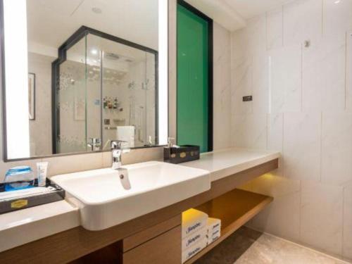 a bathroom with a white sink and a mirror at Hampton by Hilton Zhuhai Doumen in Zhuhai