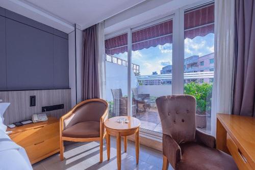 a hotel room with a table and chairs and a large window at Zhongshan Louis Hotel in Zhongshan