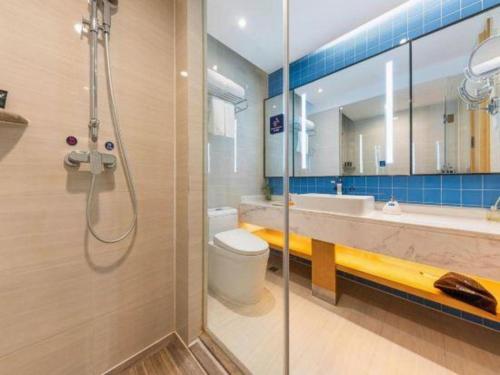a bathroom with a shower and a toilet and a sink at Kyriad Marvelous Hotel·Xi'an North High-speed Railway Station in Xi'an